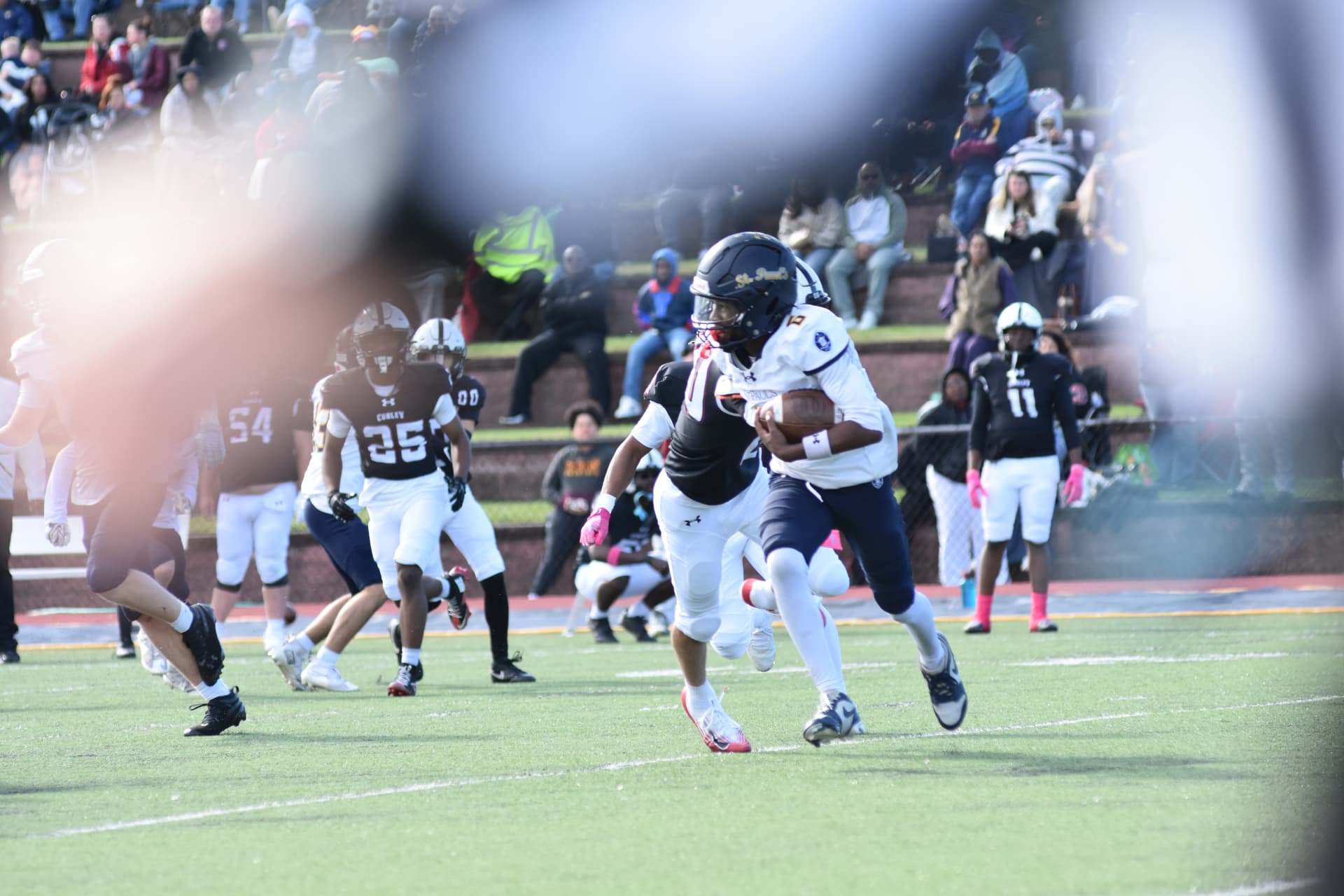 A Crusader carries the ball as Curley defenders pursue