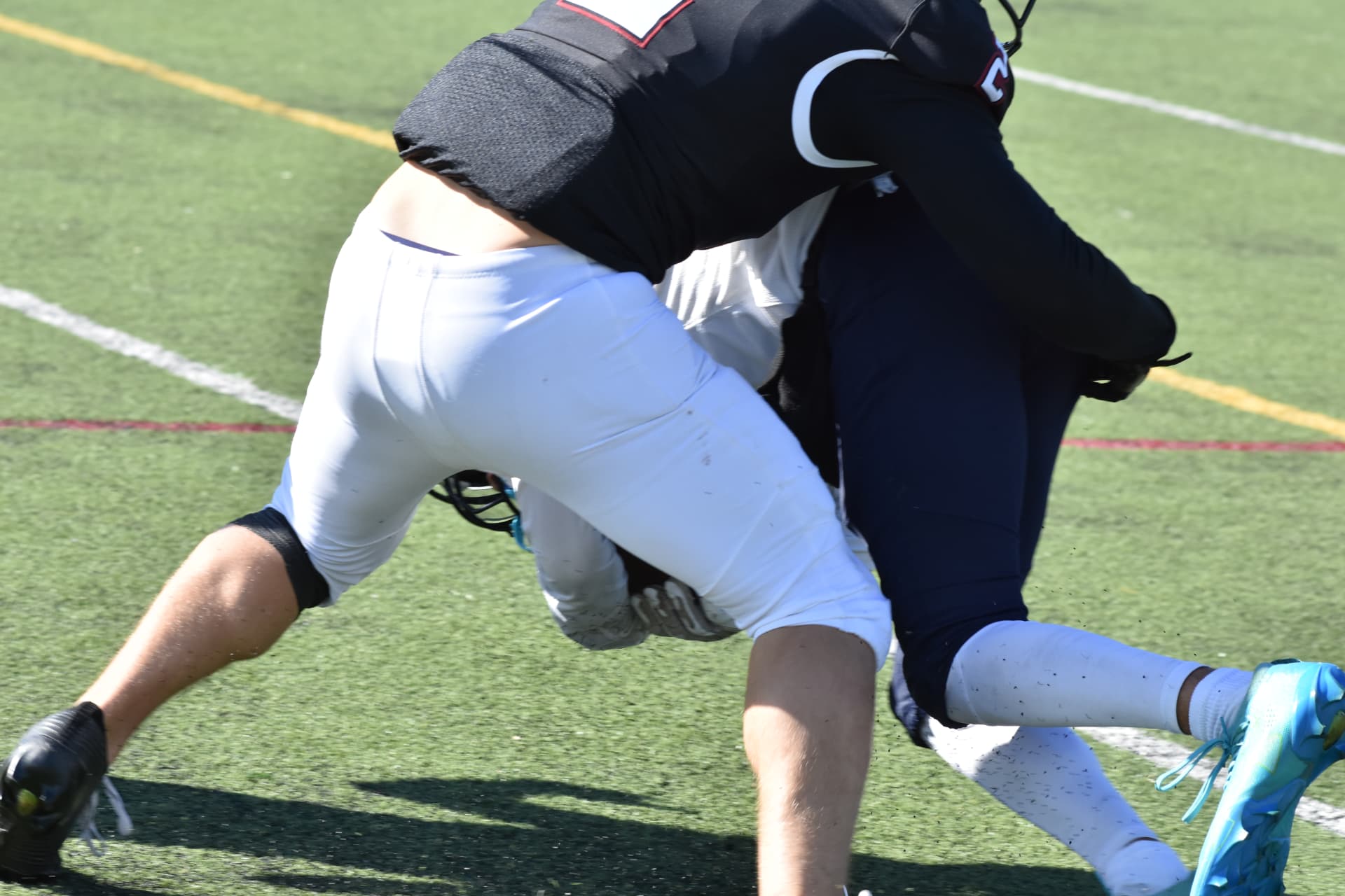 A Curley defender tackles a Crusader in a close-up action photo