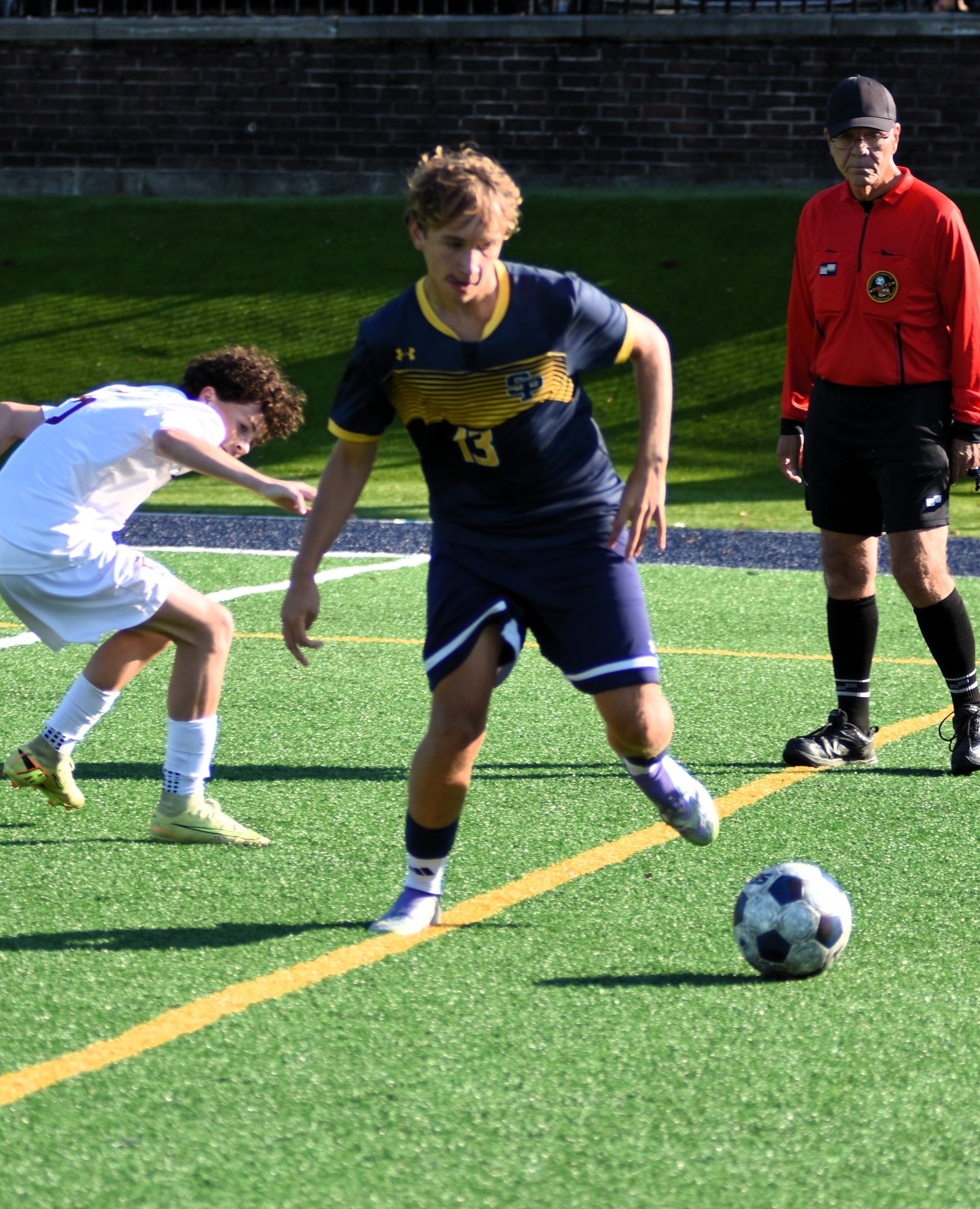 Crusaders number 13 cuts past a BL defender as the referee watches