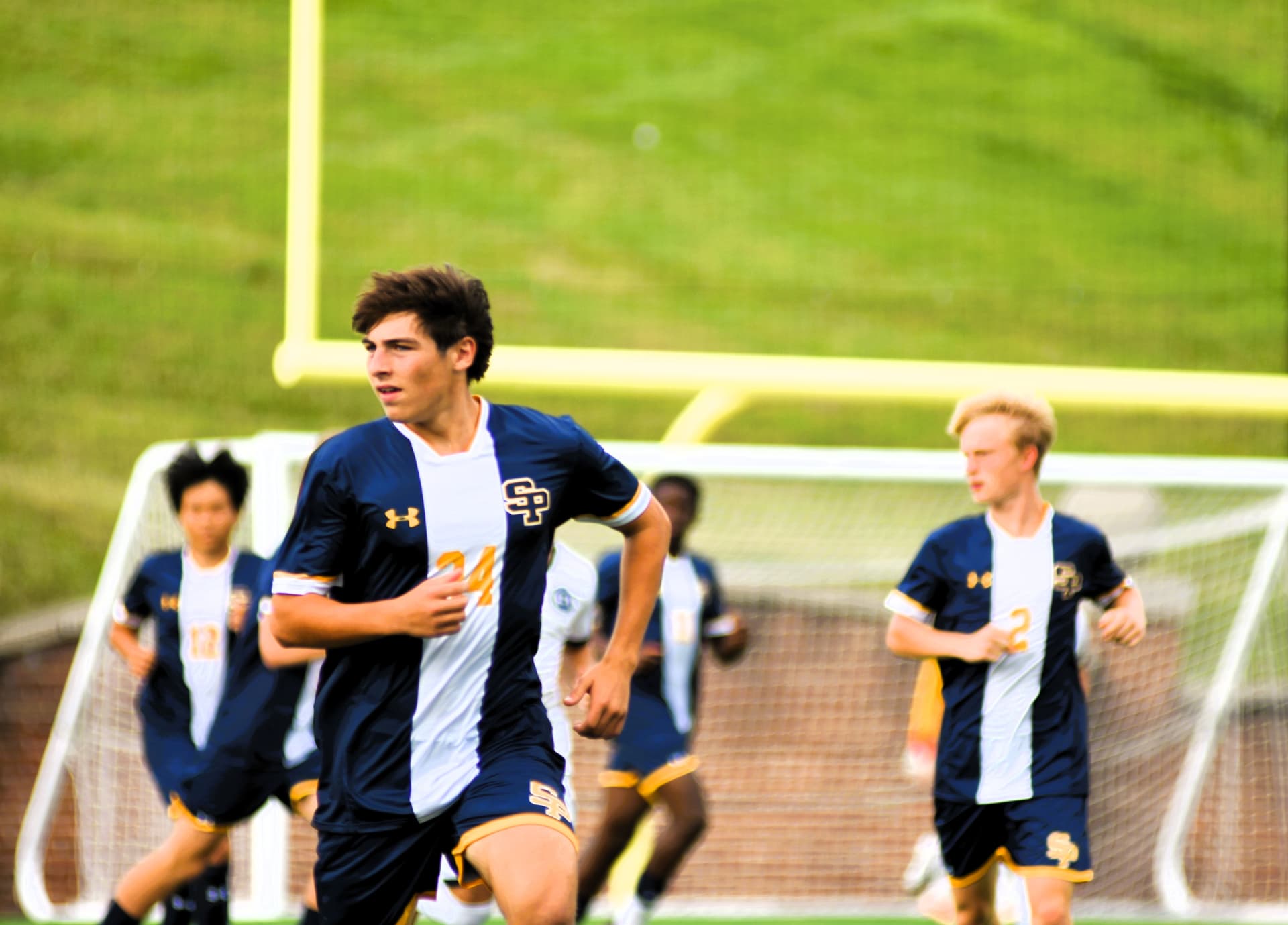 St. Paul's number 24 jogs onto the field with teammates