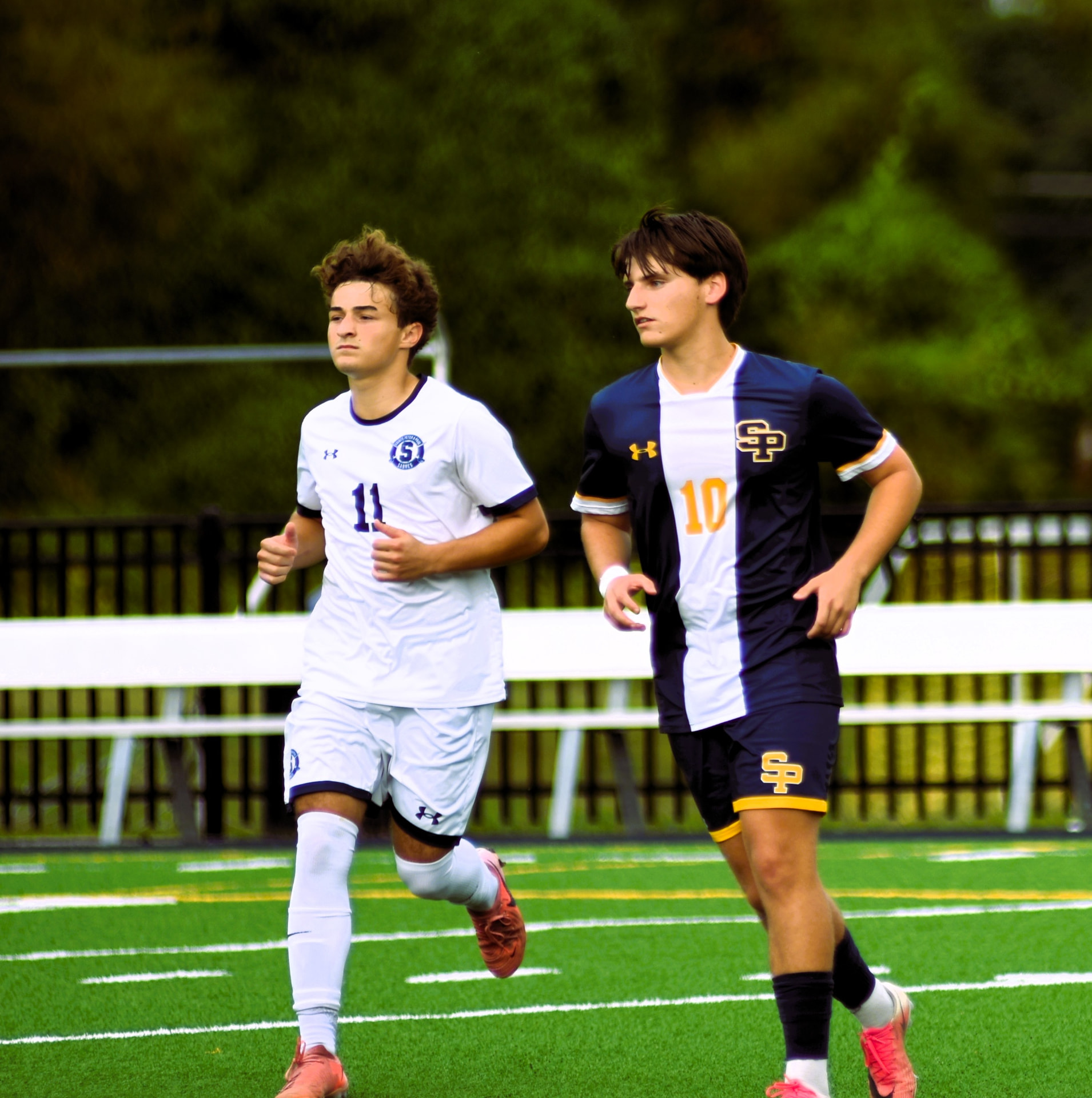 St. Paul's number 10 runs alongside a StP&P player