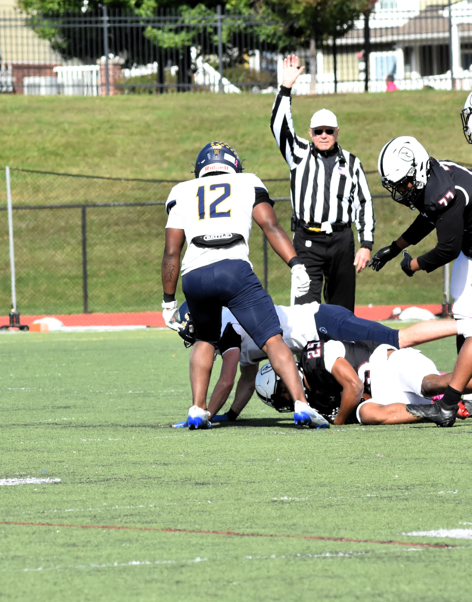 Crusaders number 12 stands beside a tackle as the referee raises his hand